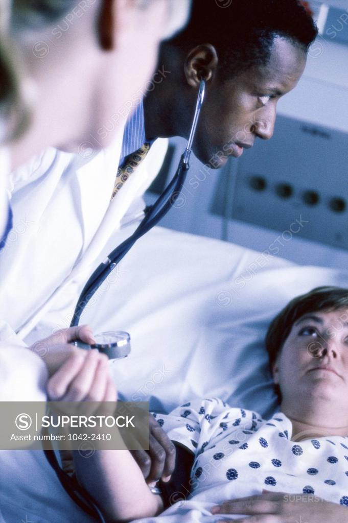 Stock Photo: 1042-2410 Male doctor checking a female patient's pulse