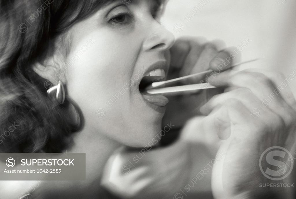 Stock Photo: 1042-2589 Close-up of a person taking a saliva sample with a cotton swab from a young woman