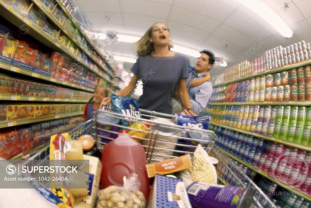 Stock Photo: 1042-2640A Mid adult woman pushing a shopping cart in a supermarket