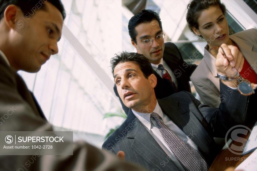 Stock Photo: 1042-2728 Three businessmen and a businesswoman in an office