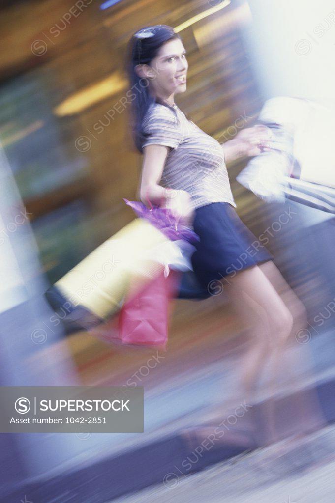 Stock Photo: 1042-2851 Side profile of a young woman carrying shopping bags