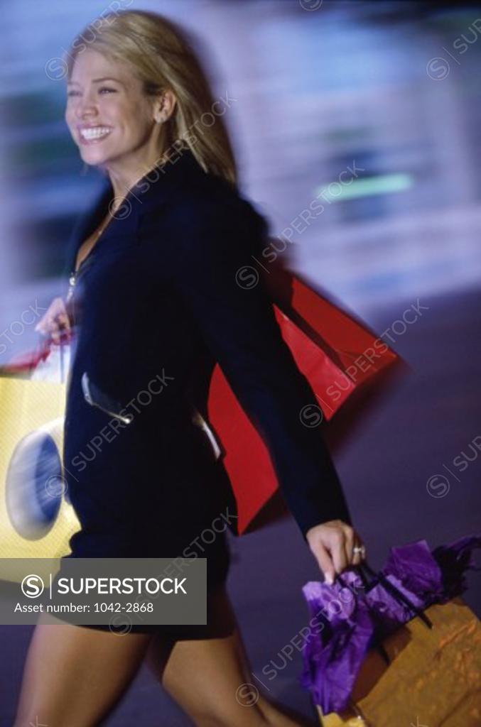 Stock Photo: 1042-2868 Side profile of a young woman carrying shopping bags