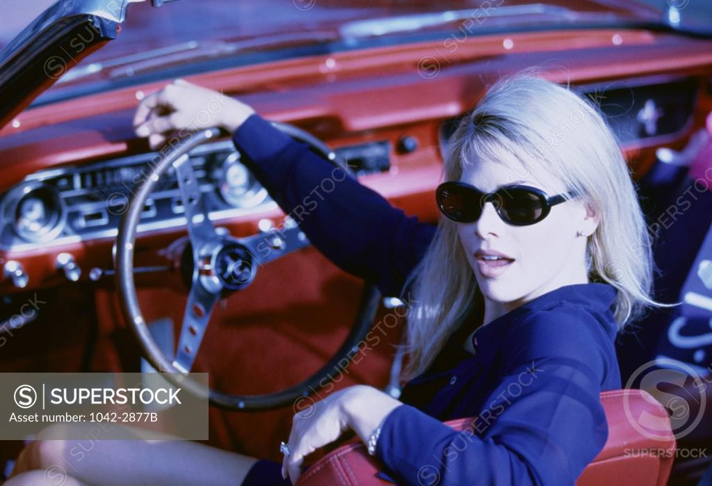 Stock Photo: 1042-2877B Portrait of a young woman sitting in car holding a steering wheel
