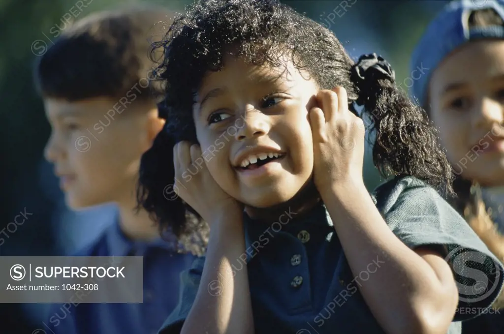 Close-up of a girl with her hands on her ears