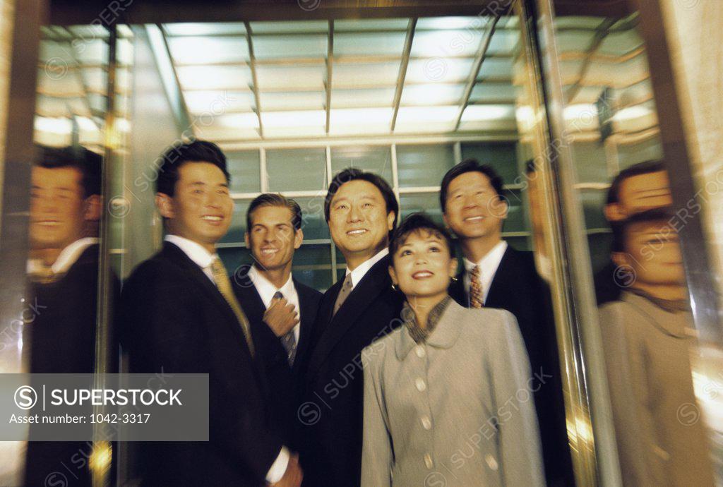 Stock Photo: 1042-3317 Low angle view of business executives standing in an elevator