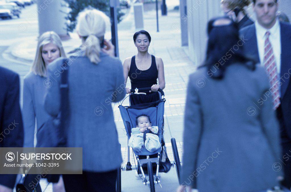Stock Photo: 1042-3395 Portrait of a mother pushing her baby boy in a stroller