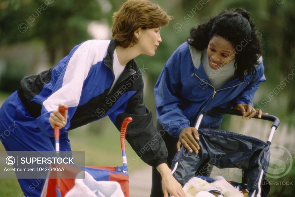 Stock Photo: 1042-3406A Two young women holding baby strollers