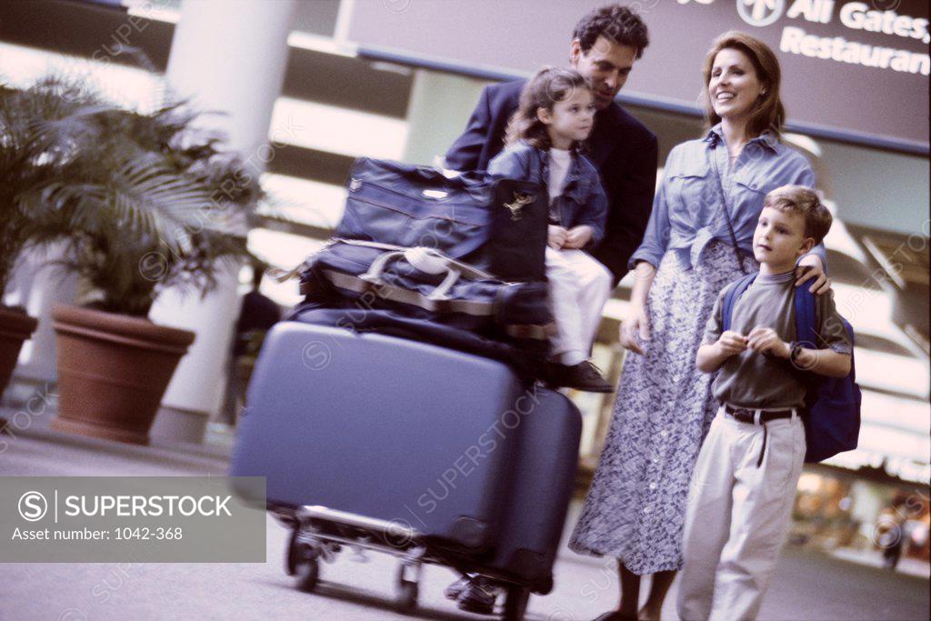Stock Photo: 1042-368 Young couple standing with their son and daughter in an airport