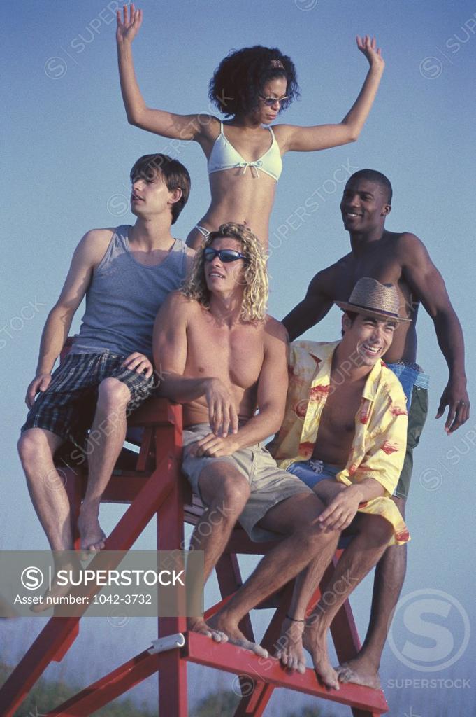 Stock Photo: 1042-3732 Low angle view of a group of young people sitting on a lifeguard chair