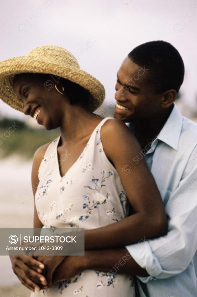 Stock Photo: 1042-3809 Young couple holding each other on the beach
