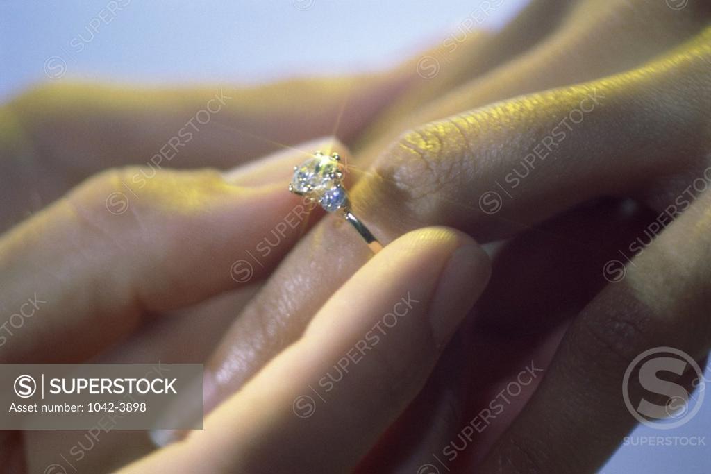 Stock Photo: 1042-3898 Close-up of a man putting on an engagement ring on a woman's finger
