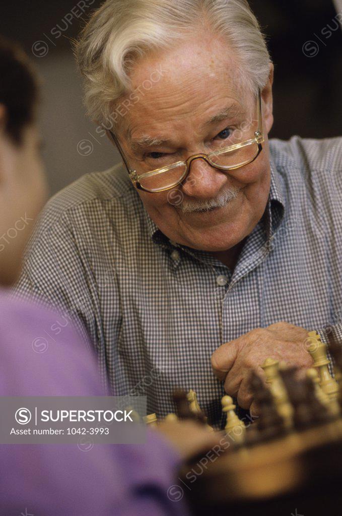 Stock Photo: 1042-3993 Grandfather playing chess with his grandson