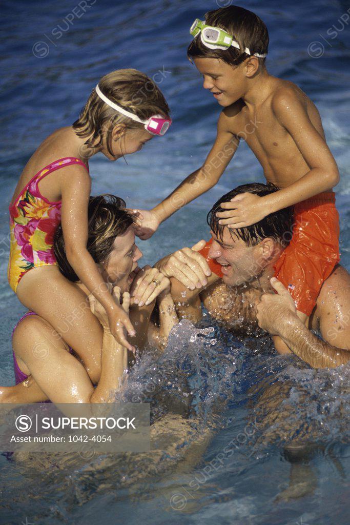 Stock Photo: 1042-4054 Son and daughter sitting on their parents shoulders