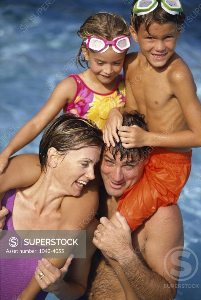 Stock Photo: 1042-4055 Son and daughter sitting on their parents shoulders