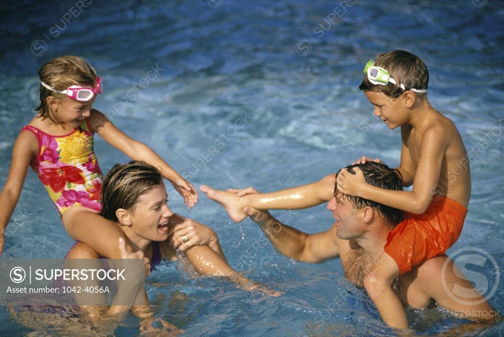Stock Photo: 1042-4056A Young couple in a swimming pool with their son and daughter