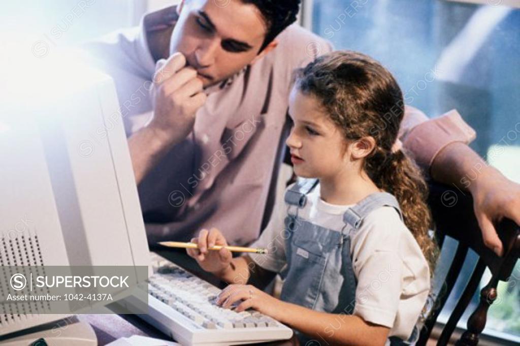 Stock Photo: 1042-4137A Young man with his daughter sitting in front of a desktop PC