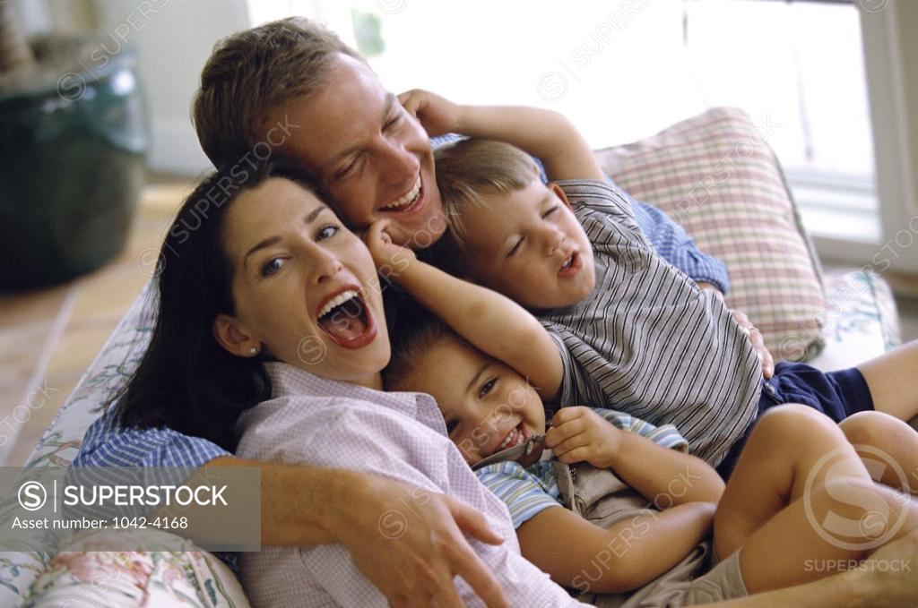 Stock Photo: 1042-4168 Parents sitting on a couch with their son and daughter