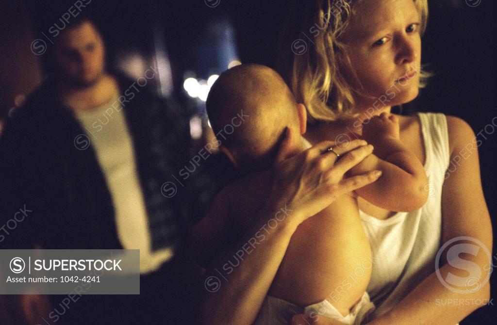 Stock Photo: 1042-4241 Mother carrying her baby boy with a mid adult man behind her