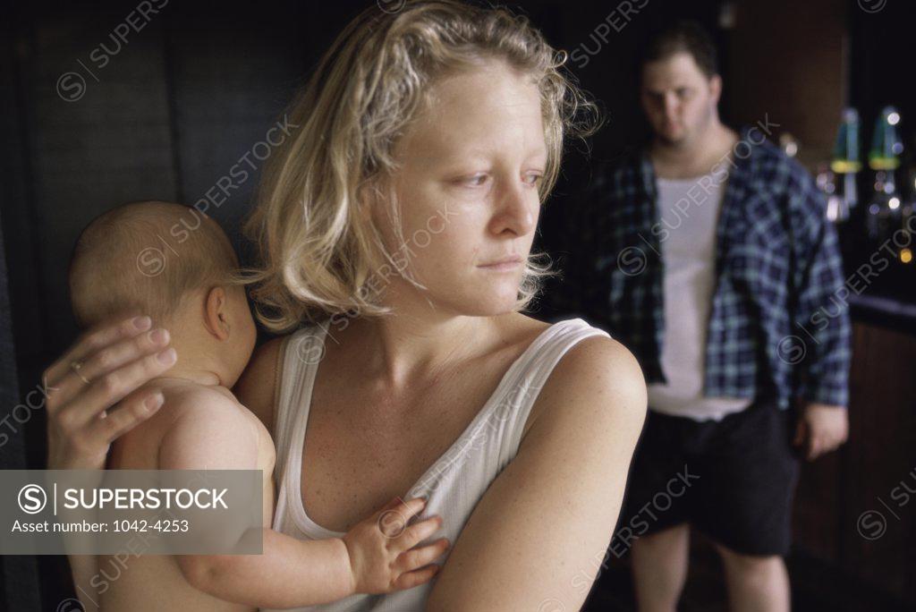 Stock Photo: 1042-4253 Mother holding her baby boy with a mid adult man standing behind her