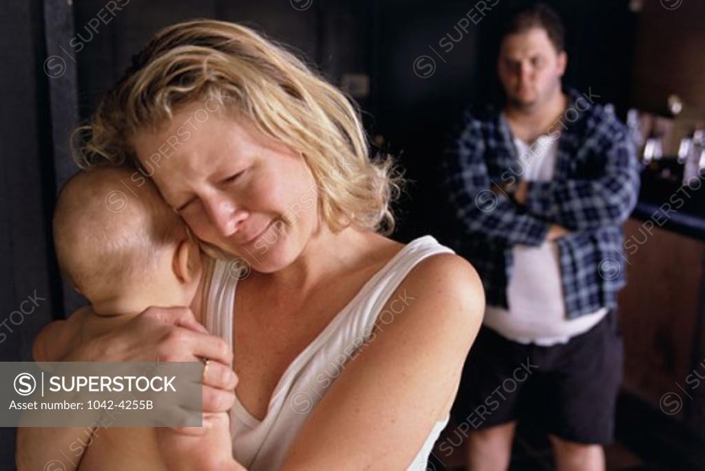 Stock Photo: 1042-4255B Mid adult woman holding her son and a mid adult man standing behind her