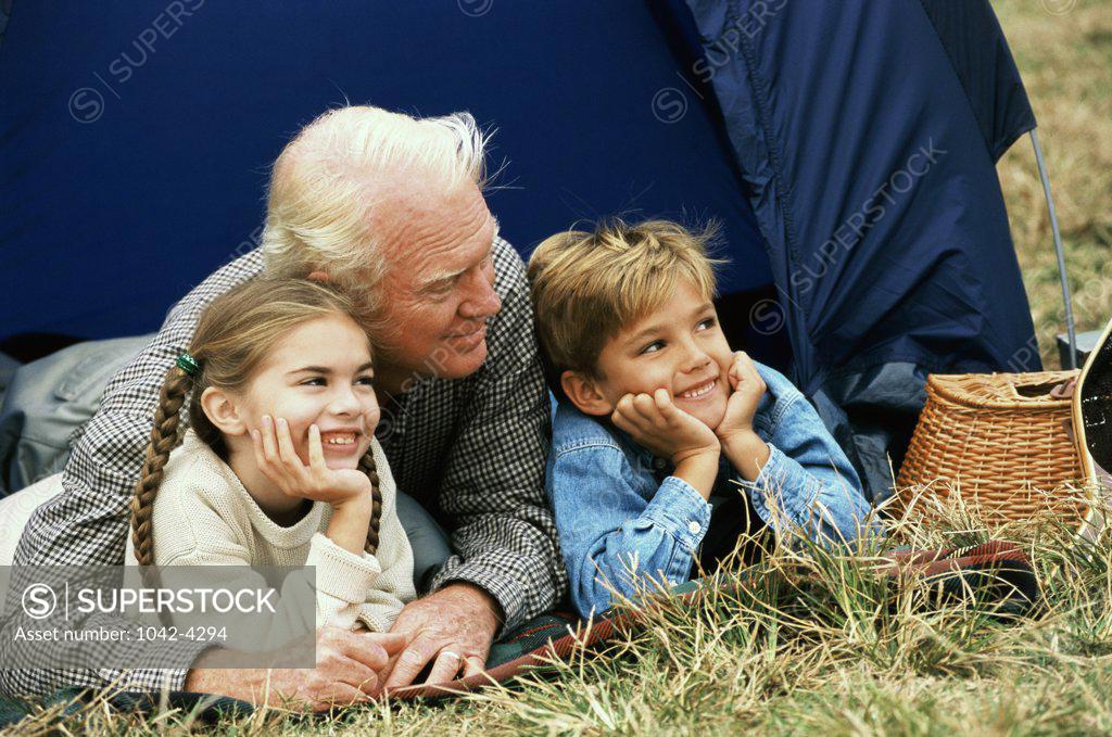 Stock Photo: 1042-4294 Portrait of an elderly man lying in a tent with his grandchildren