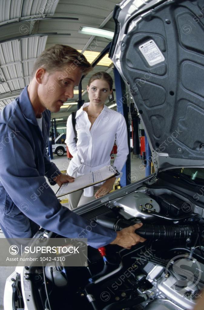Stock Photo: 1042-4310 Young woman standing with a mechanic