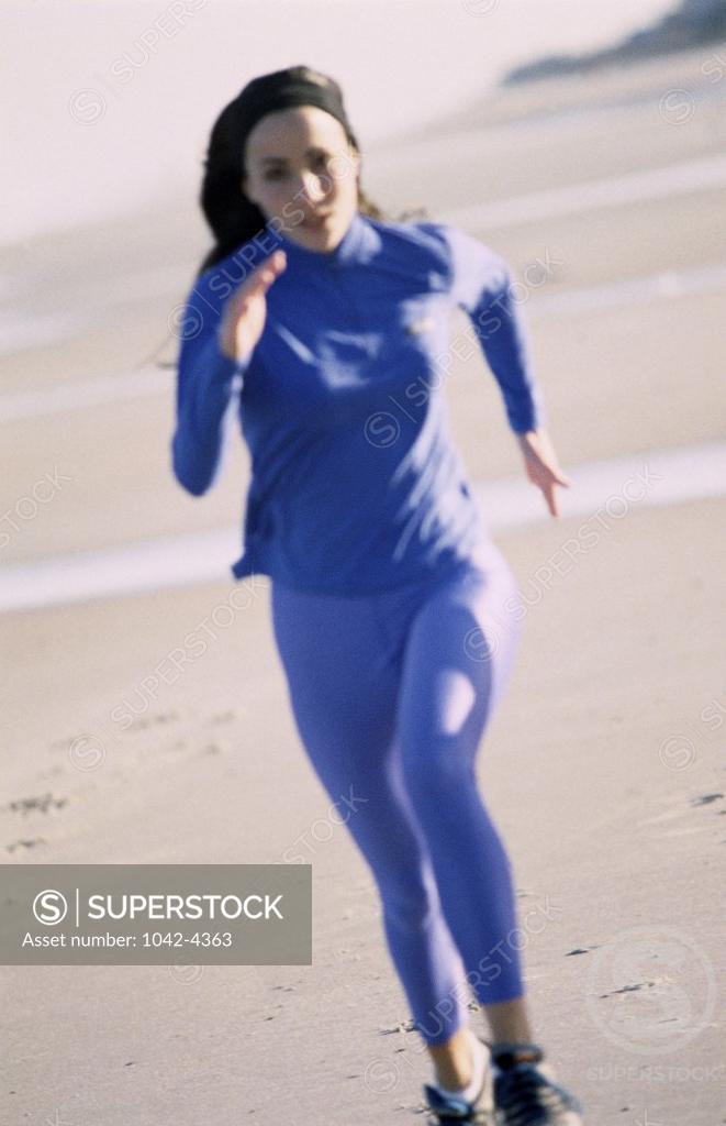 Stock Photo: 1042-4363 Portrait of a young woman jogging on the beach