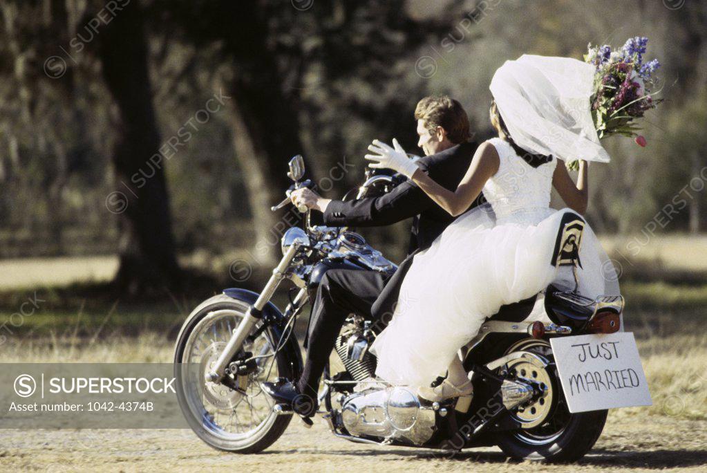 Stock Photo: 1042-4374B Rear view of a newlywed couple riding on a motorcycle