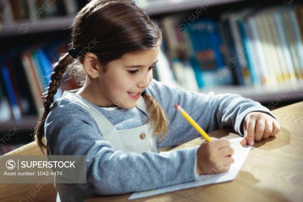 Stock Photo: 1042-4474 Girl writing with a pencil on a sheet of paper