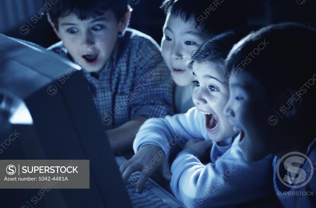 Stock Photo: 1042-4481A Group of boys laughing in front of a computer monitor