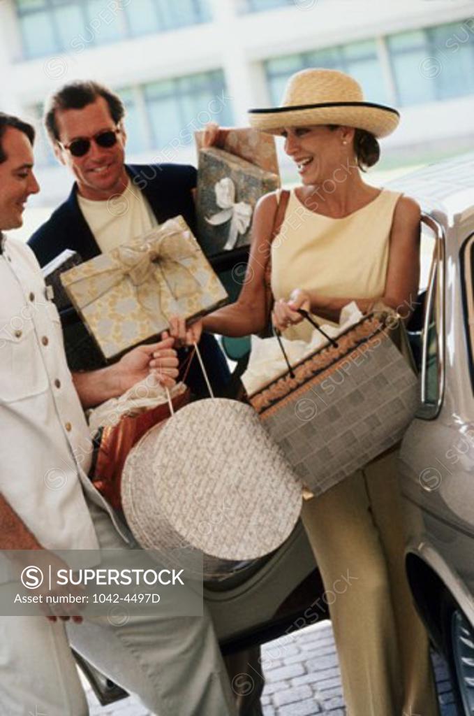 Stock Photo: 1042-4497D Personal valet carrying a mid adult woman's shopping bags