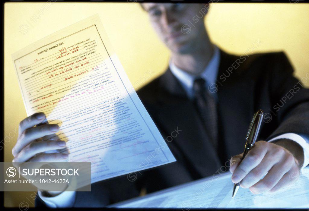 Stock Photo: 1042-4622A Businessman writing on paper