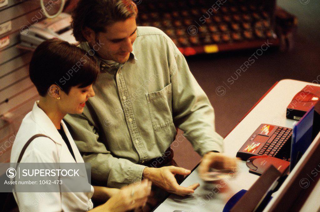 Stock Photo: 1042-473 High angle view of a young couple standing at a checkout counter