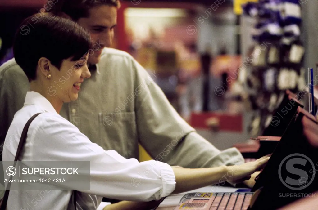 Side profile of a young couple shopping for a computer