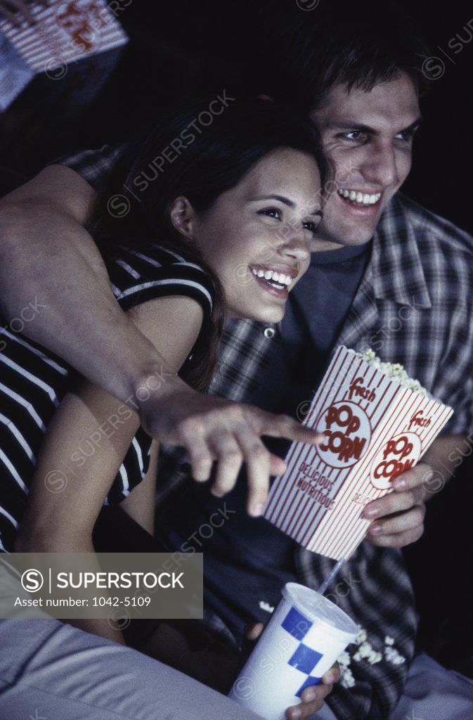 Stock Photo: 1042-5109 Young couple sitting in a theater watching a movie