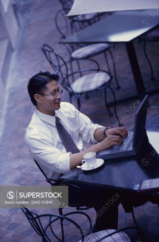 Stock Photo: 1042-5184C High angle view of a businessman sitting in a cafe using a laptop