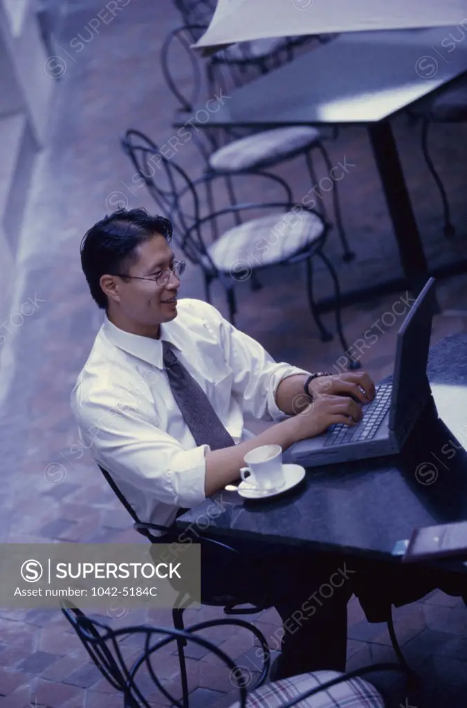 High angle view of a businessman sitting in a cafe using a laptop