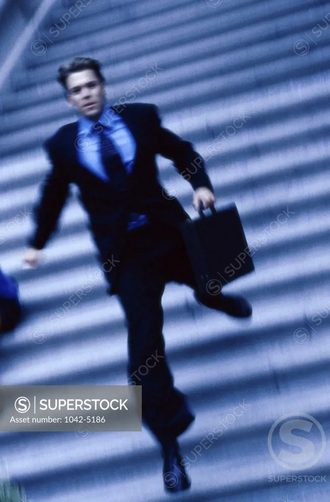 Businessman running down a staircase with a briefcase