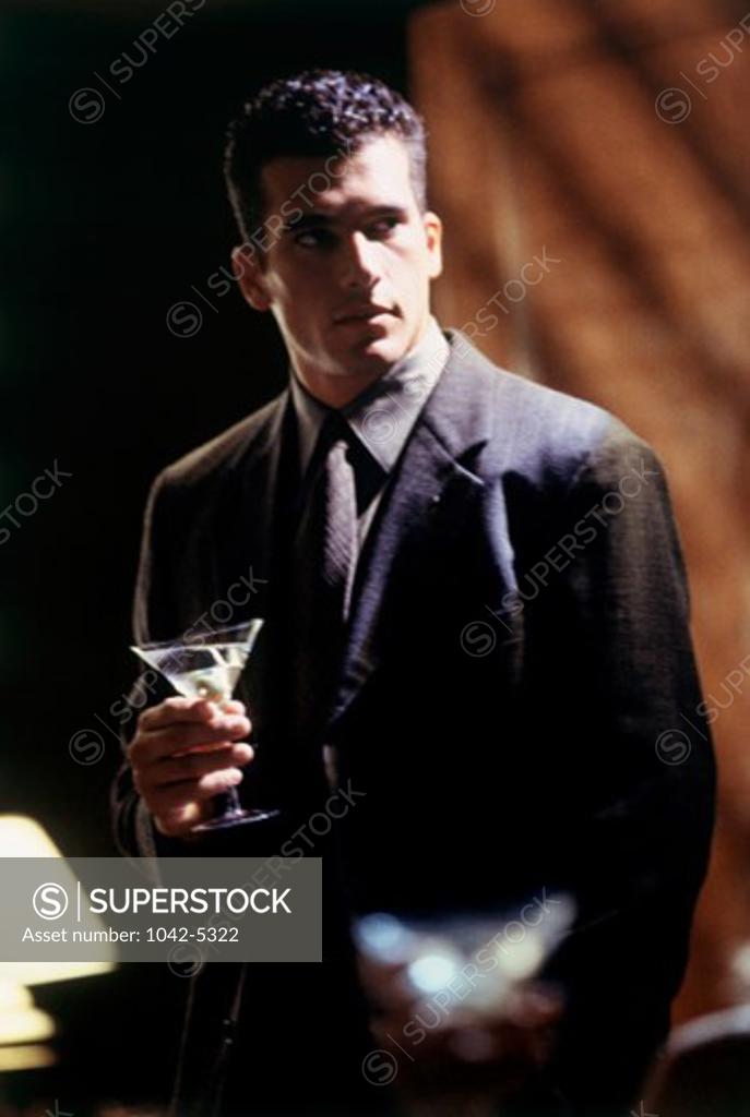 Stock Photo: 1042-5322 Young man holding a martini
