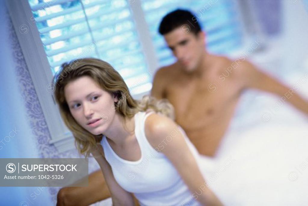 Stock Photo: 1042-5326 Young couple sitting on a bed