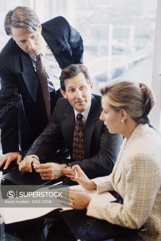 Stock Photo: 1042-535B Two businessmen and a businesswoman in an office