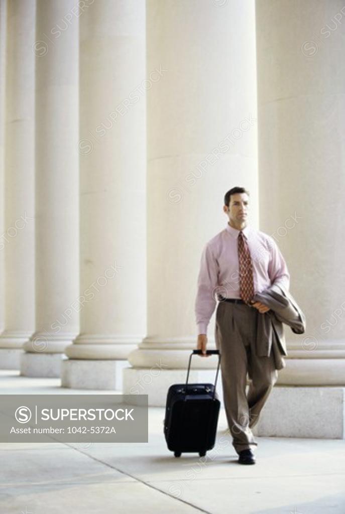 Stock Photo: 1042-5372A Businessman walking with luggage