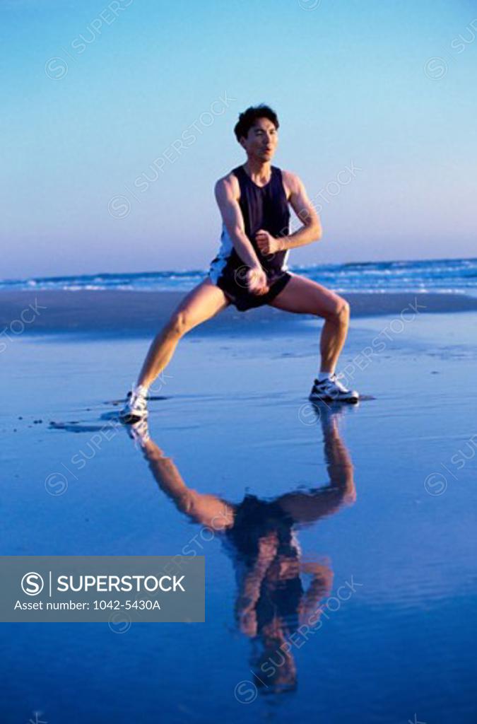 Stock Photo: 1042-5430A Young man practicing martial arts on the beach