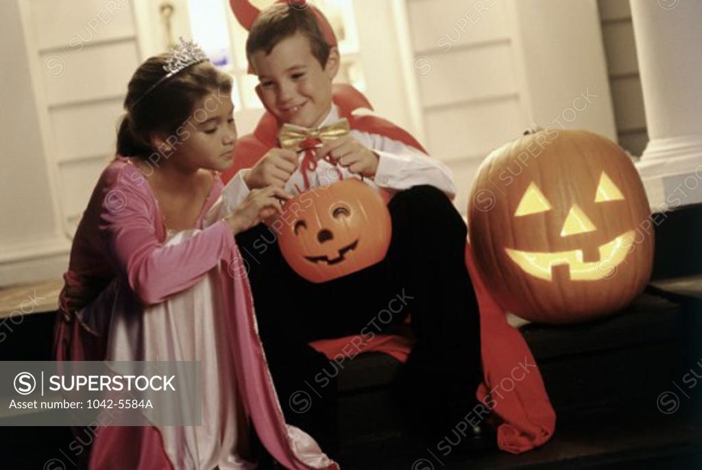 Stock Photo: 1042-5584A Boy and a girl trick or treating at Halloween