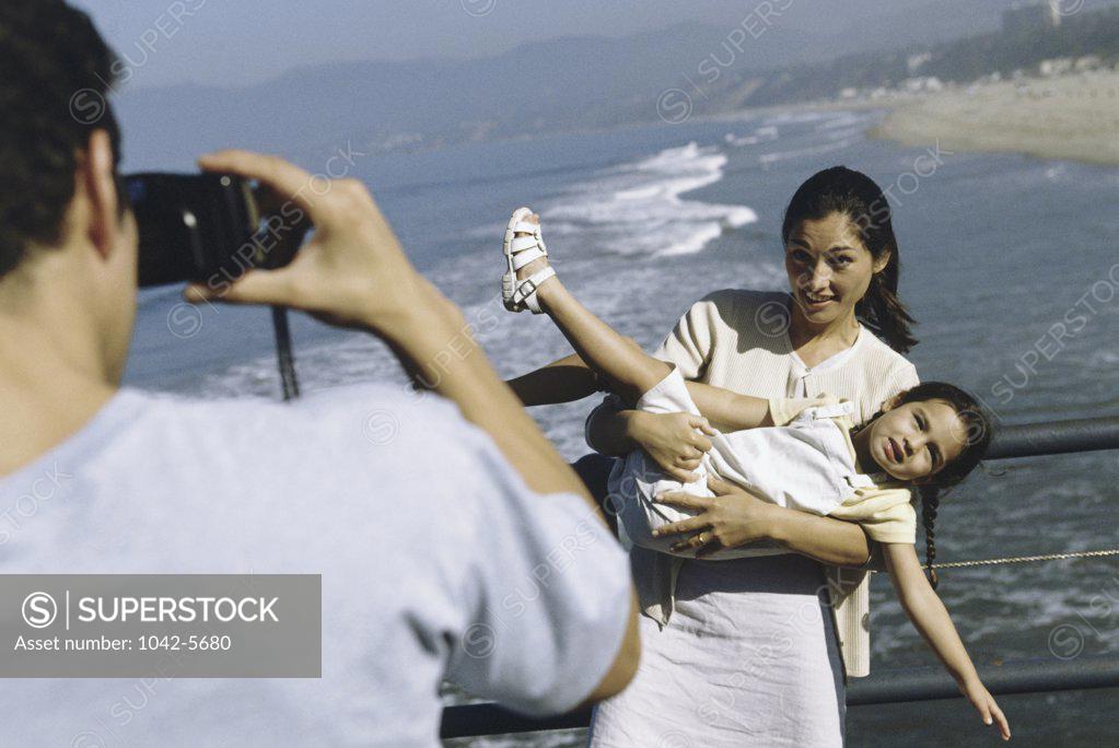 Stock Photo: 1042-5680 Father taking a photograph of his wife and daughter