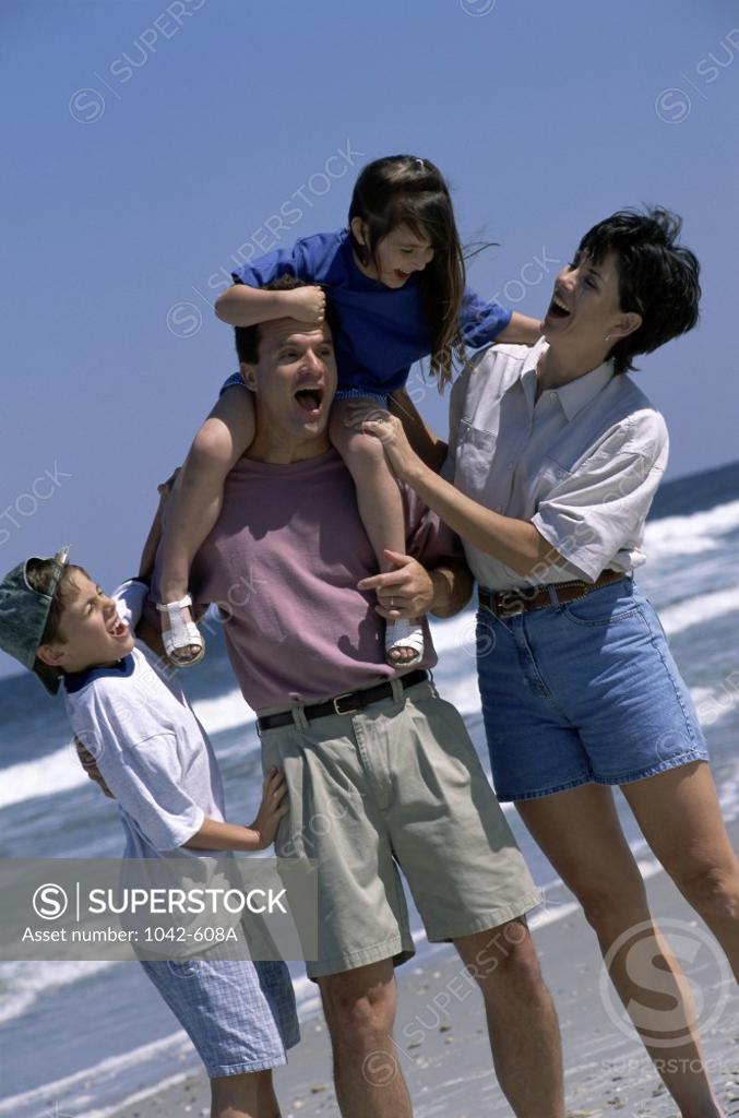 Stock Photo: 1042-608A Young couple playing on the beach with their son and daughter