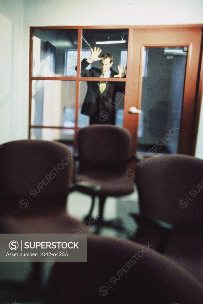 Stock Photo: 1042-6423A Businessman standing against a window