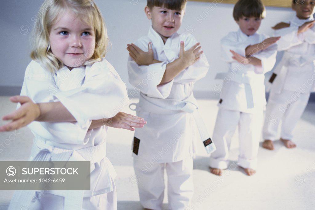 Stock Photo: 1042-6459 Girl and three boys practicing karate