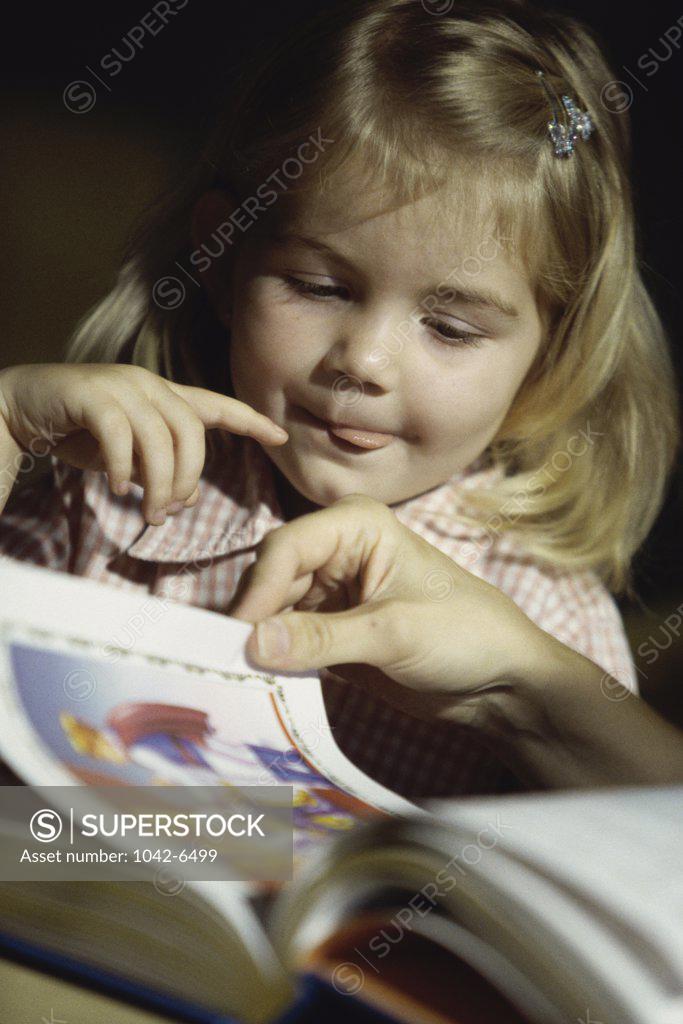 Stock Photo: 1042-6499 Girl looking at a book