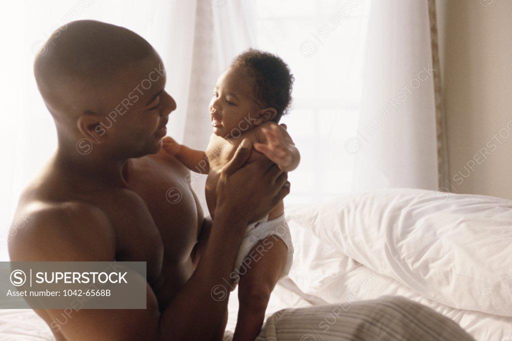 Stock Photo: 1042-6568B Man playing with a baby